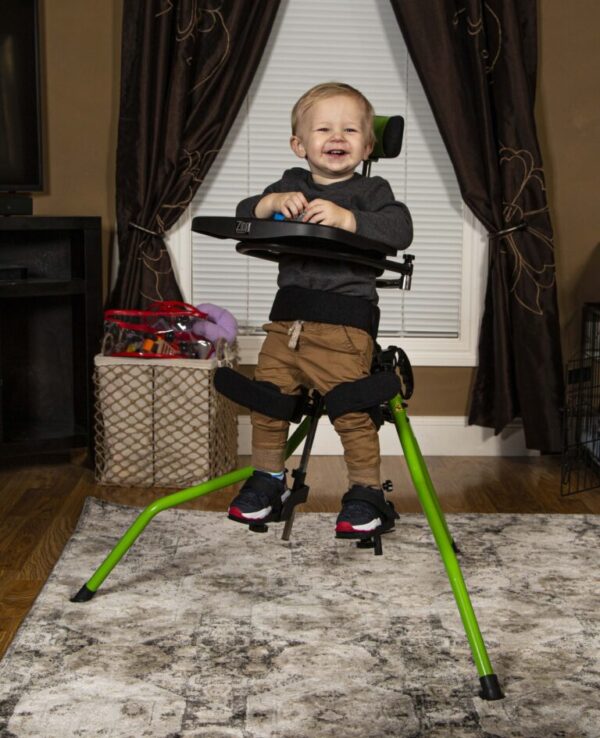 Zing Portable Stander with a toddler standing and smiling.